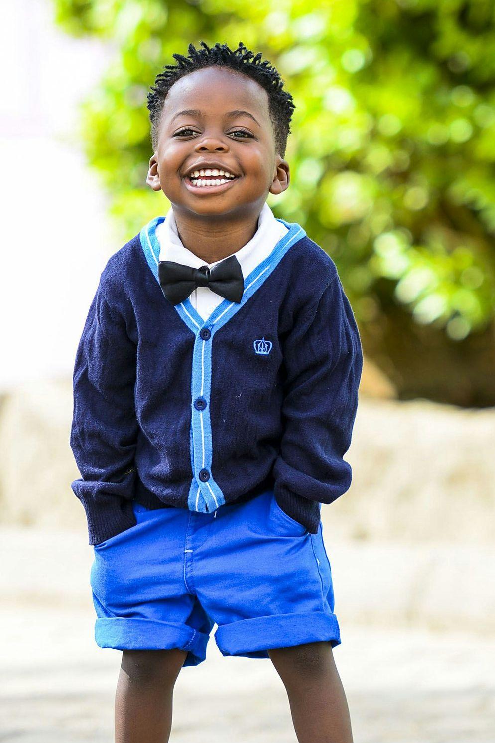 selective focus photo of boy standing on grey pavement